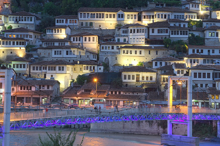 Berat old town Mangalem quarter with Ottoman traditional houses built on a hill slope, pictured in the evening with city lights on