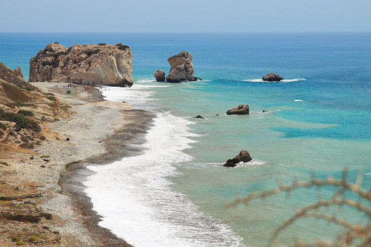 Beach with sand and sea with rock formations visible ahead of the coastline 