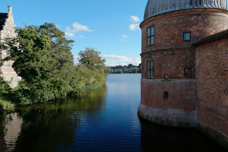 Castle moat with a red brick side of the castle in the photo