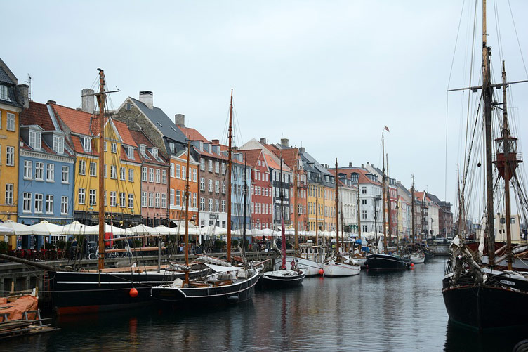 Brightly coloured waterfront buildings behind a waterbody with boats