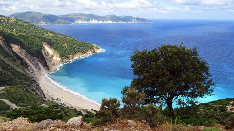 Birds eye view of a Cephalonia bay with blue sea, white sands and cliffs on one side