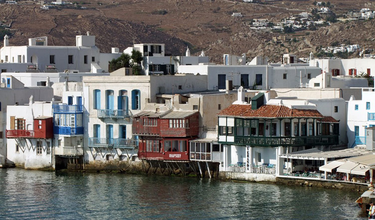 Waterfront houses with balconies hovering over the water at Little Venice of Mykonos Island, Greece