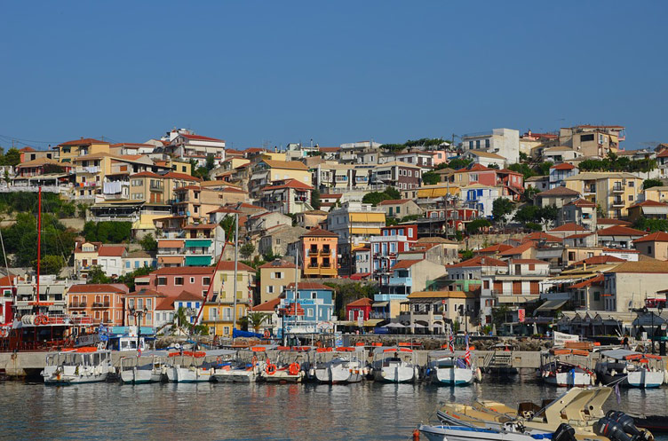 A colourful coastal town with boats docked at the front