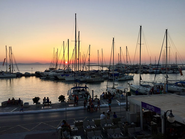 Docked sailing boats at Naxos island port at sunset, Greece