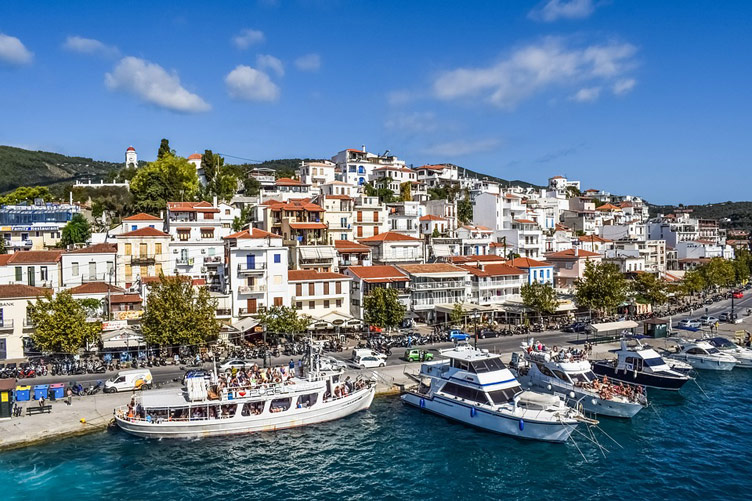 Sea, boats and coastal town of Skiathos Chora on Skiathos Island, Greece