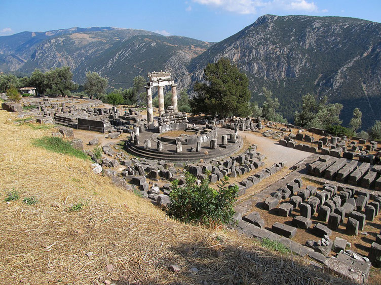 A view from above of ancient temple in ruins set against a backdrop of mountains