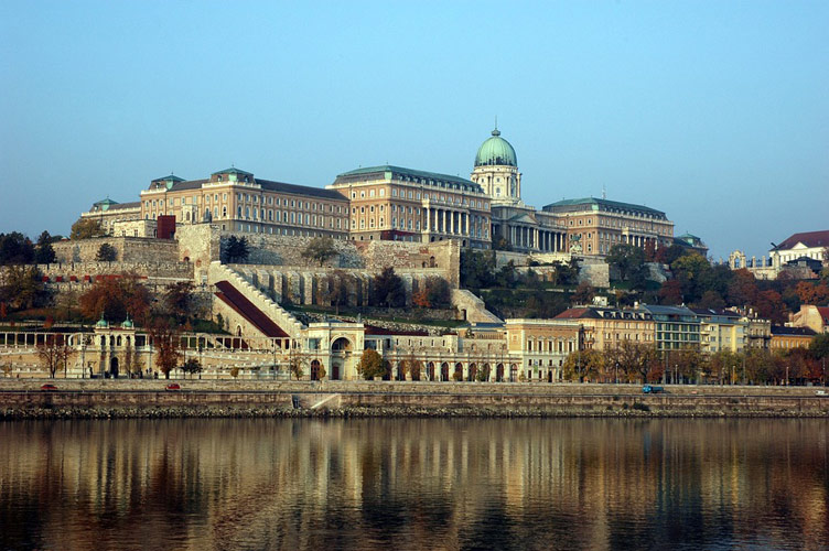 A massive castle complex visible on the other side of water body 