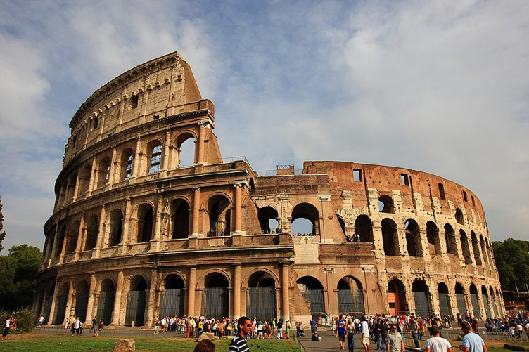 The Roman Colosseum aka Flavian Amphitheatre in daytime with visitors dotted around