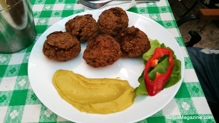 Traditional Romanian meatballs with sauce served on a plate and presented on a table at La Mahala Romanian restaurant