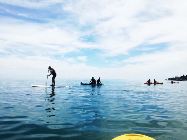 A small group of people paddle surf-ing on the Malaga coast in Spain